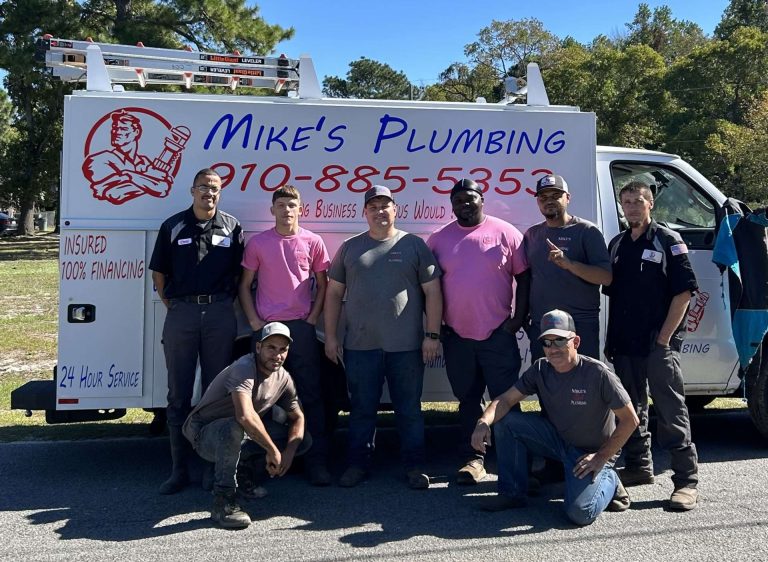Mike's Plumbing team posing in front of service vehicle, showcasing commitment to quality plumbing services and community engagement.